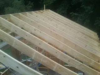 New roof rafters set over an addition before sheathing in Mediapolis