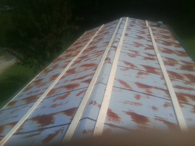 Rusted metal roof panels with new wood purlins before replacement — Storm Damage Roof Repair in Mediapolis by Roofing Brothers