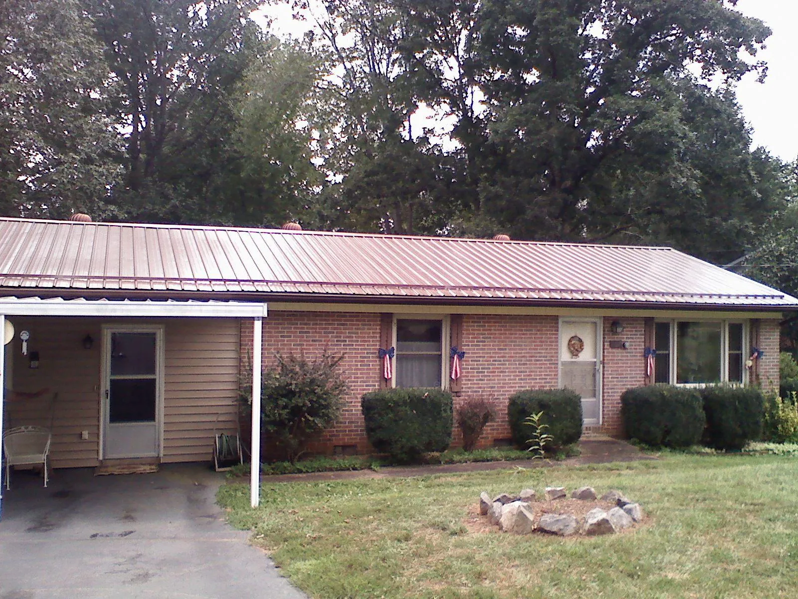 Bronze metal roof and carport on a brick ranch home — Roof Repair work by our crew in Mediapolis