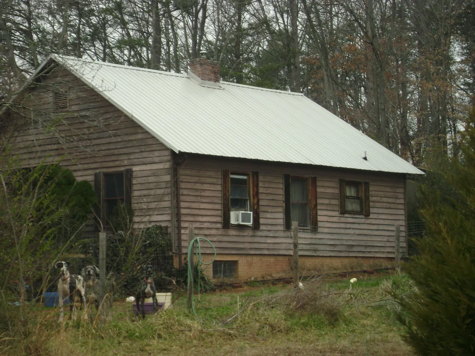 White metal roof on an old wood sided farmhouse, from a Metal Roof Installation job in Mediapolis